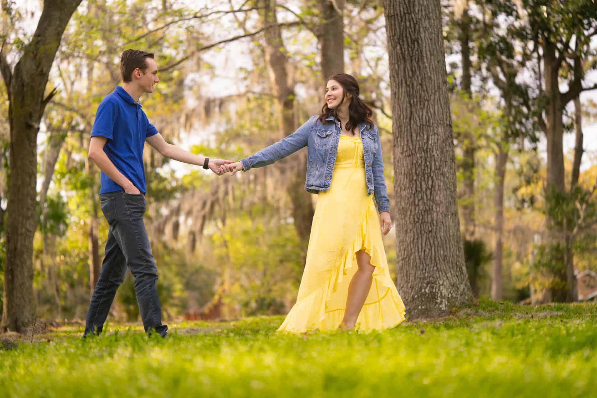 Young couple holding hands in Riverside Park during fall.
