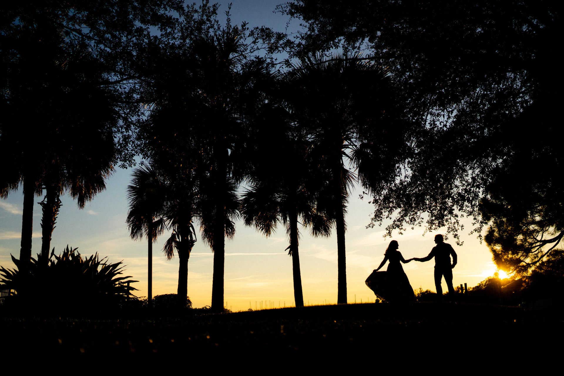 Silhouette of a couple holding hands at sunset in Riverside Park.