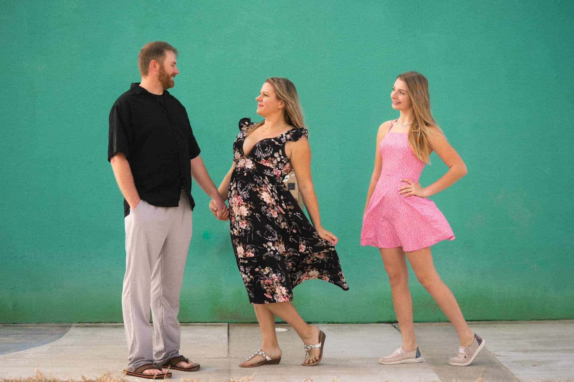 Three people standing in front of a green screen, engaging in conversation.