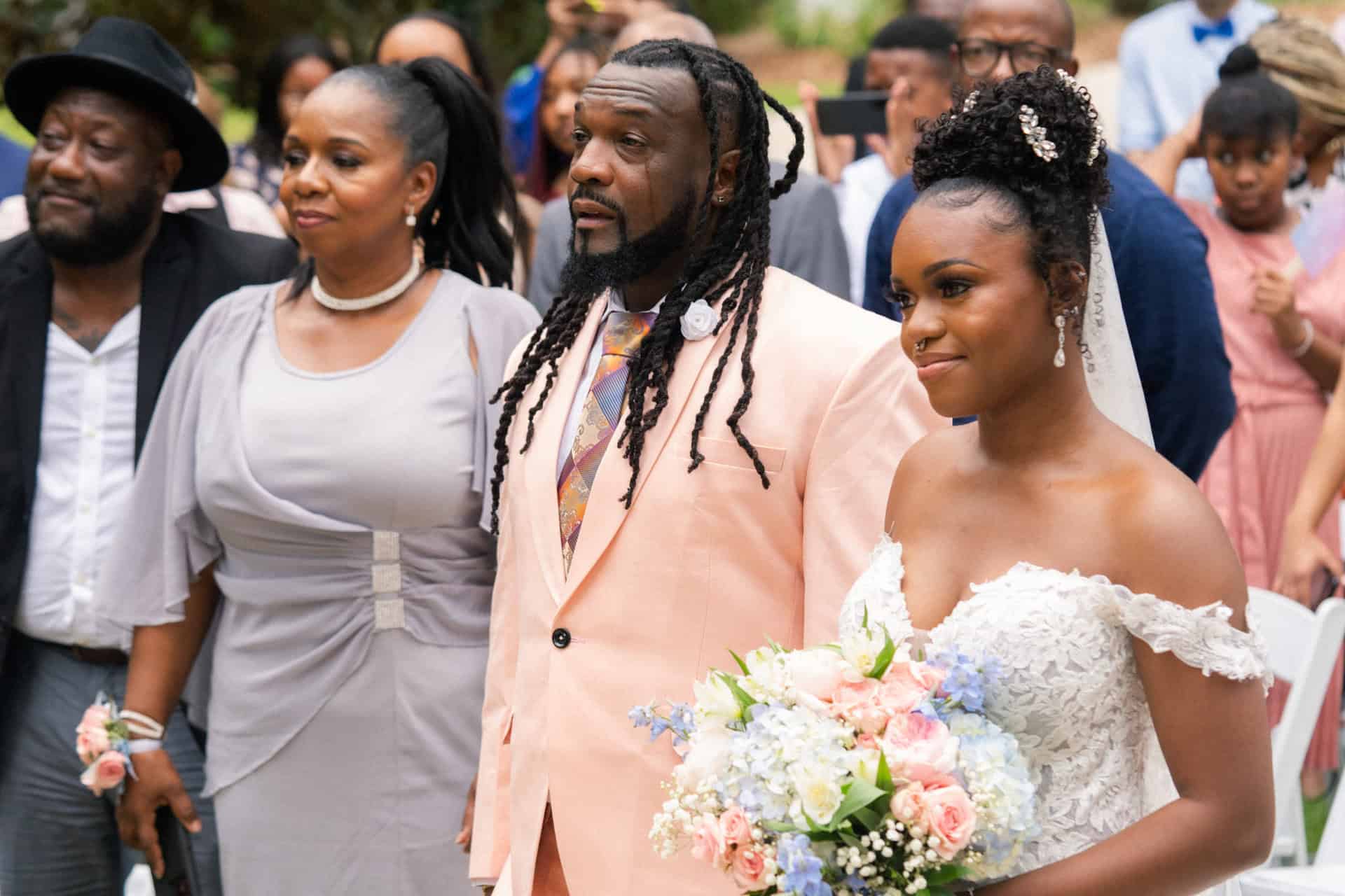 Bride and groom with wedding guests at outdoor ceremony.
