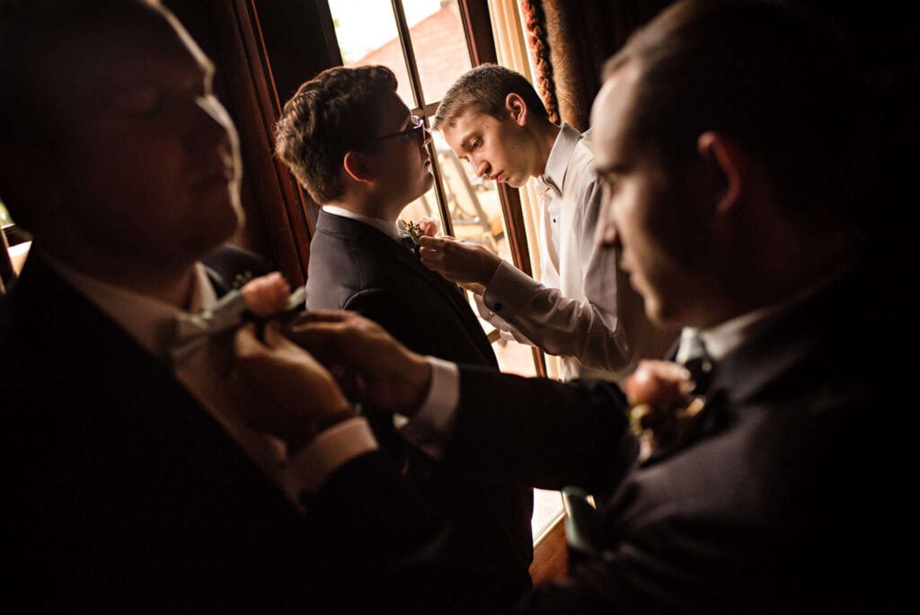 Groom getting ready with groomsmen in stylish suits at a wedding.