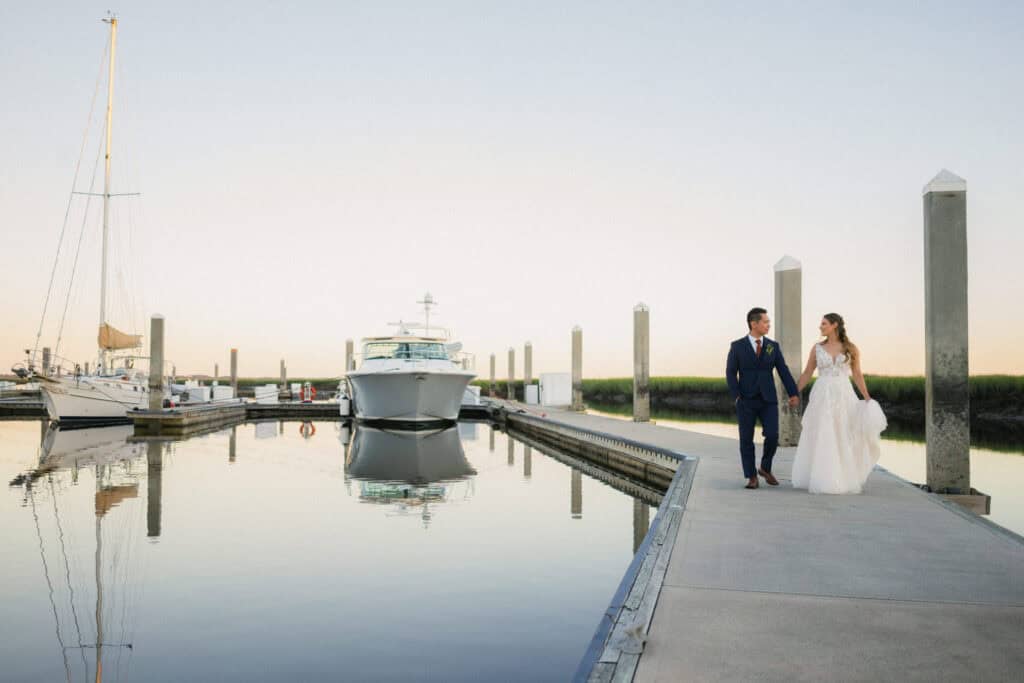 Bride and groom walking along the marina at Fernandina Beach during sunset.