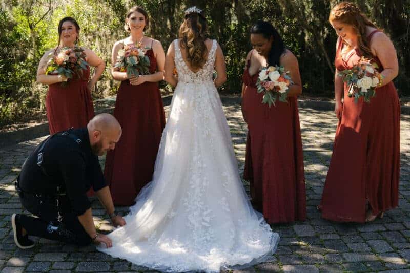 Bride with bridesmaids and photographer during wedding shoot.