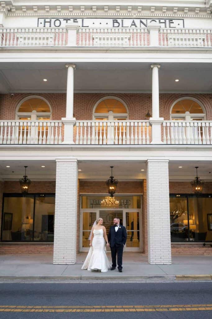 Wedding couple in front of Hotel Blanche, elegant wedding photography.