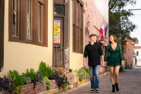 Man and woman hold hands walking through downtown St. Augustin, FL