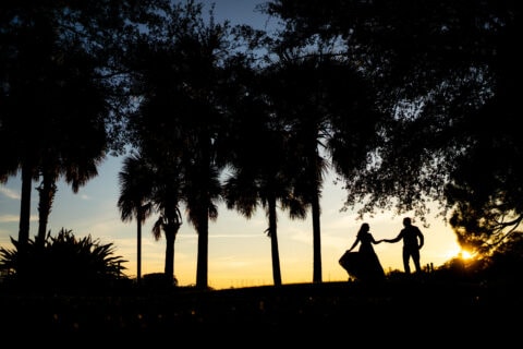 Silhouette of a man and a woman holding hands against the backdrop of the sunset