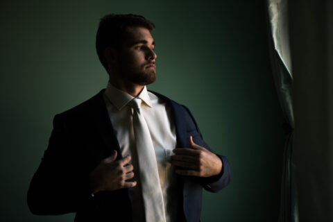 Groom adjusts his suit jacket