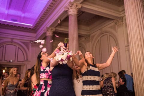 Bridesmaids try to catch the bride's bouquet