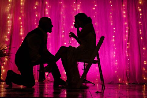 Silhouette of bride and groom at wedding reception with pink background
