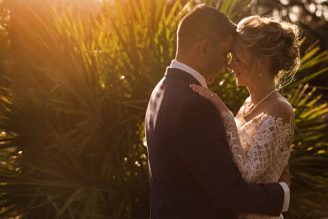 Bride and groom hold each other during sunset