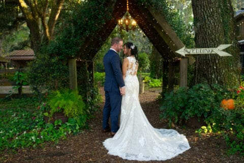 Bride and groom hold each other with greenery in the background